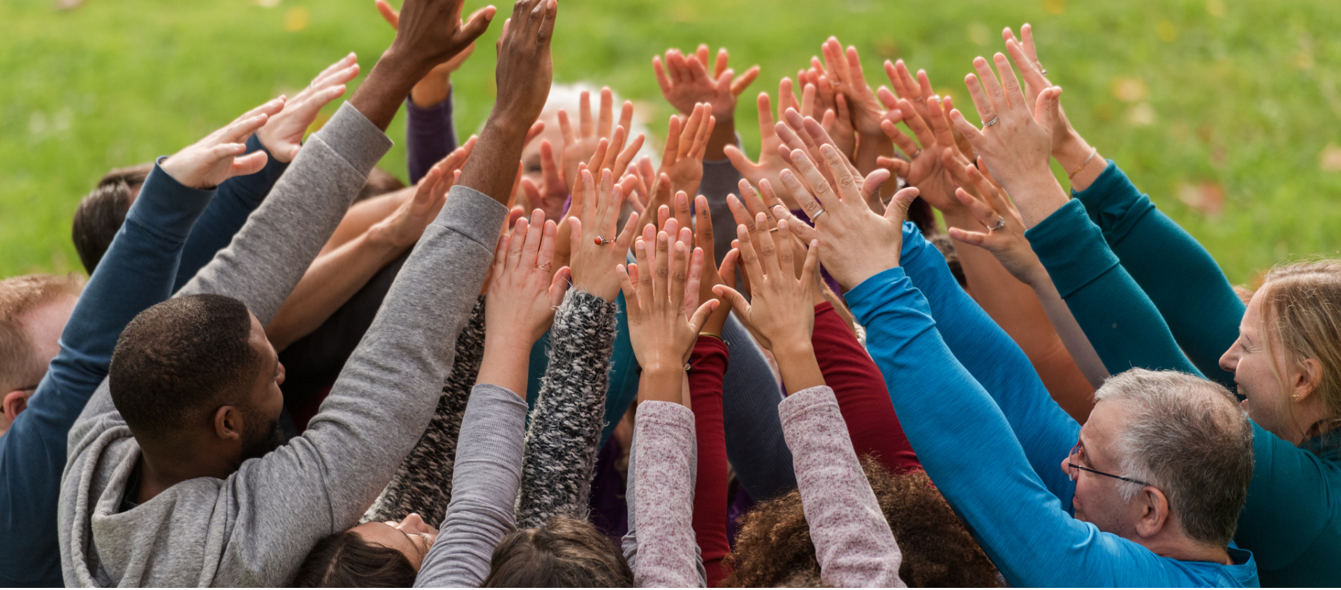 Group of people with hands raised.