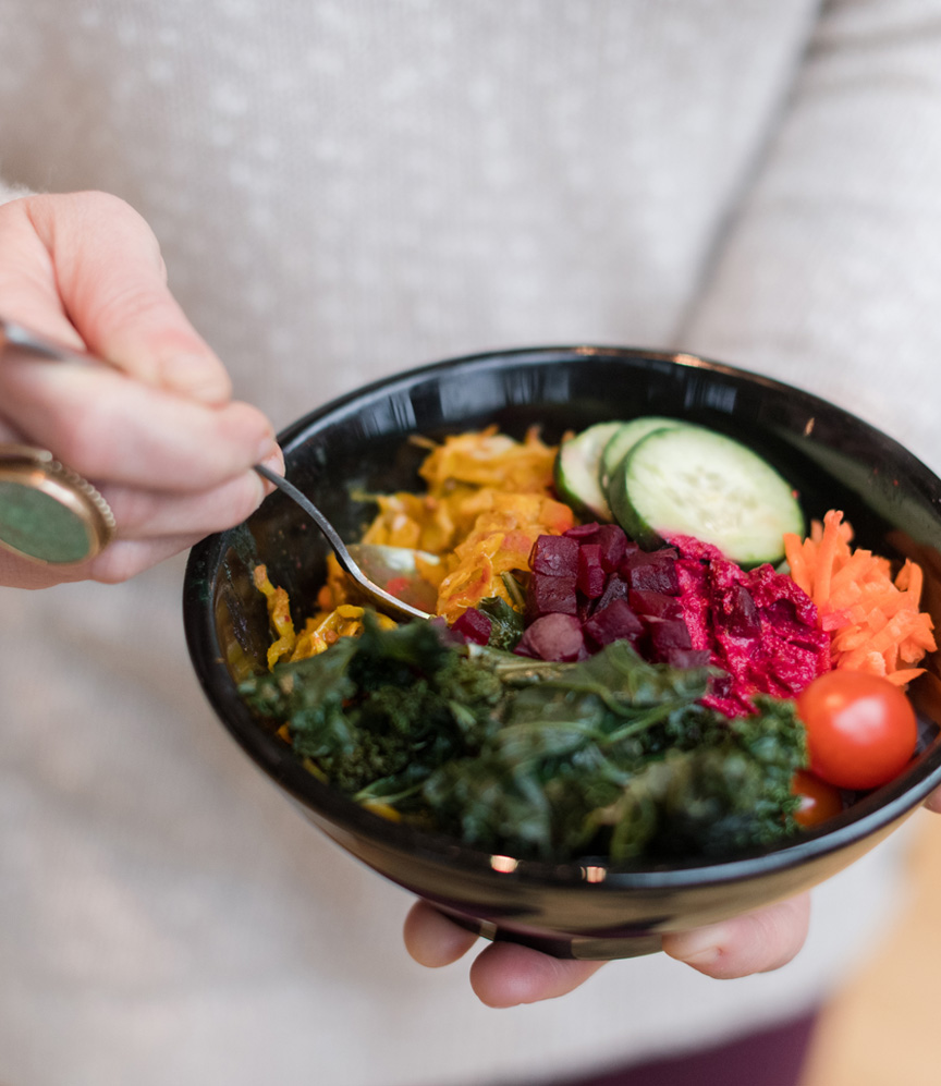 A woman holds a buddha bowl