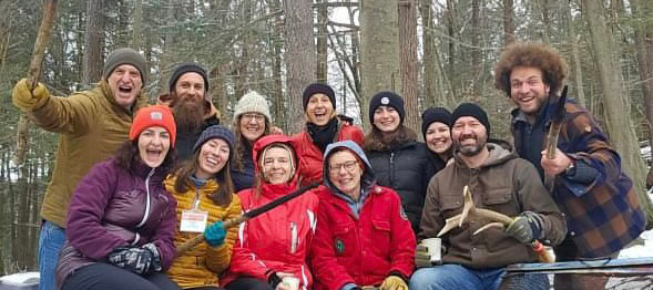 Group of smiling, exuberant people triumphant in the winter woods