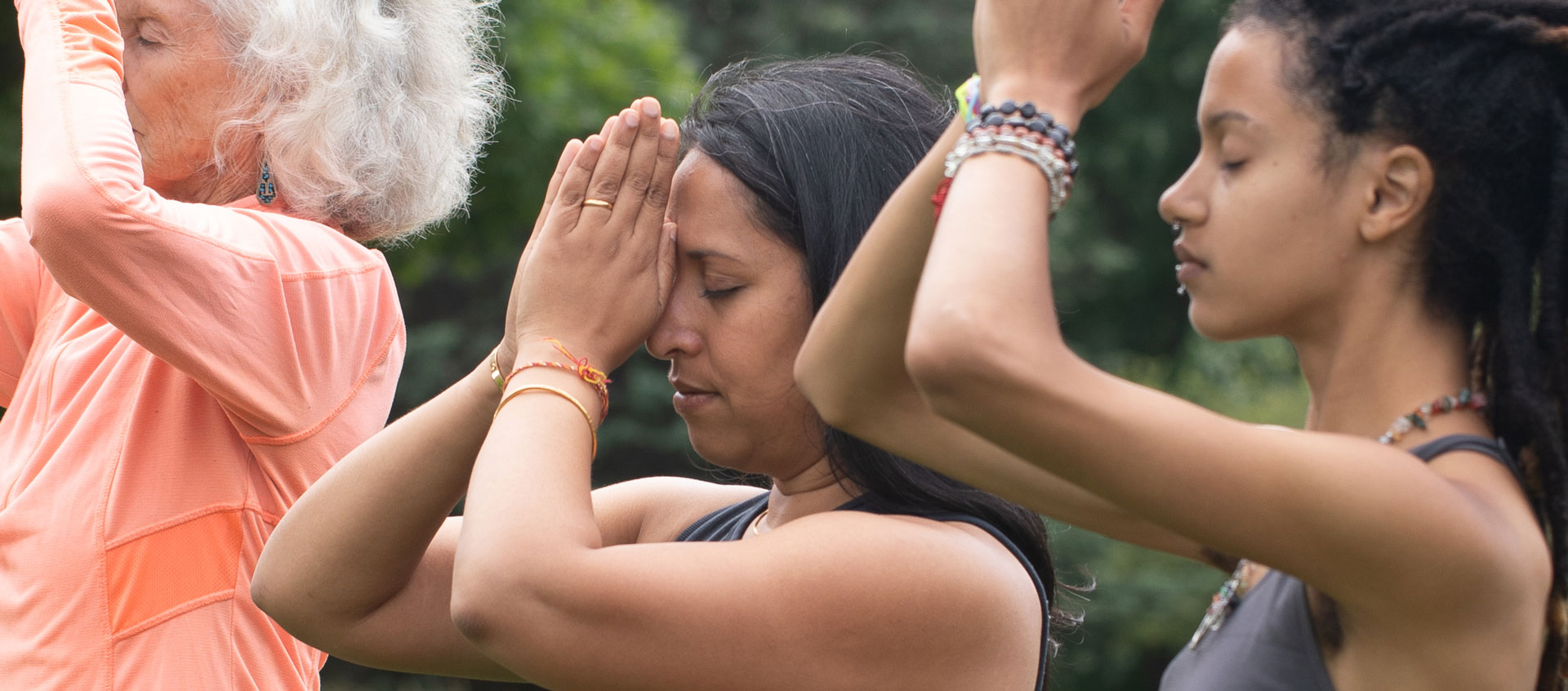 three women with hands at forehead