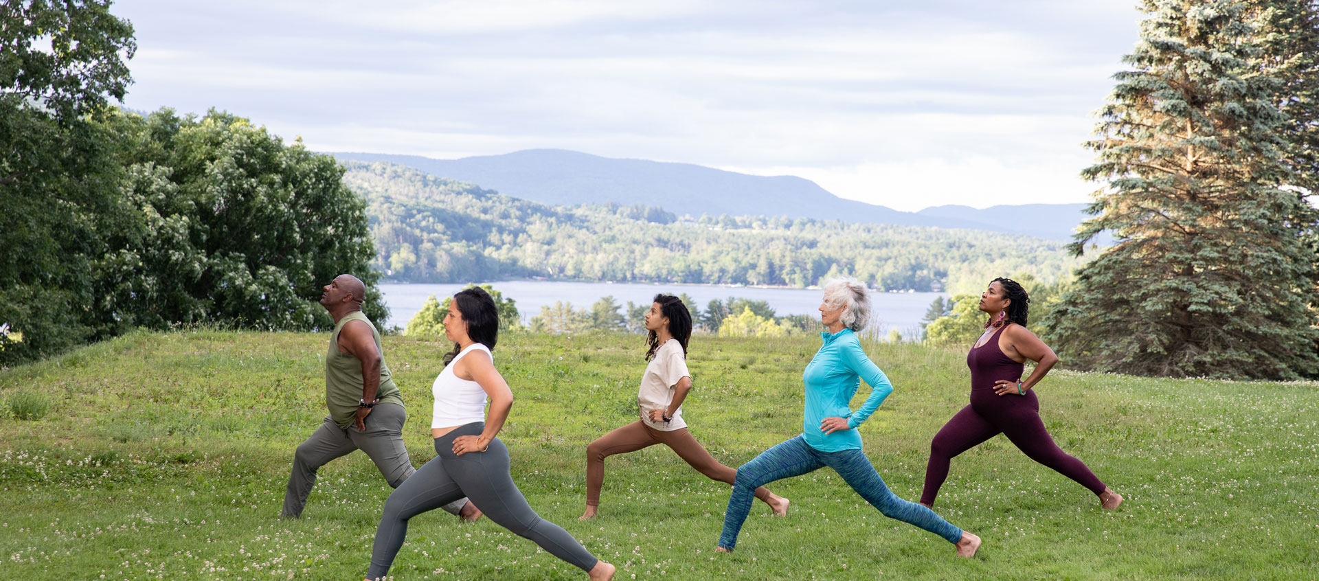 five people doing yoga outside