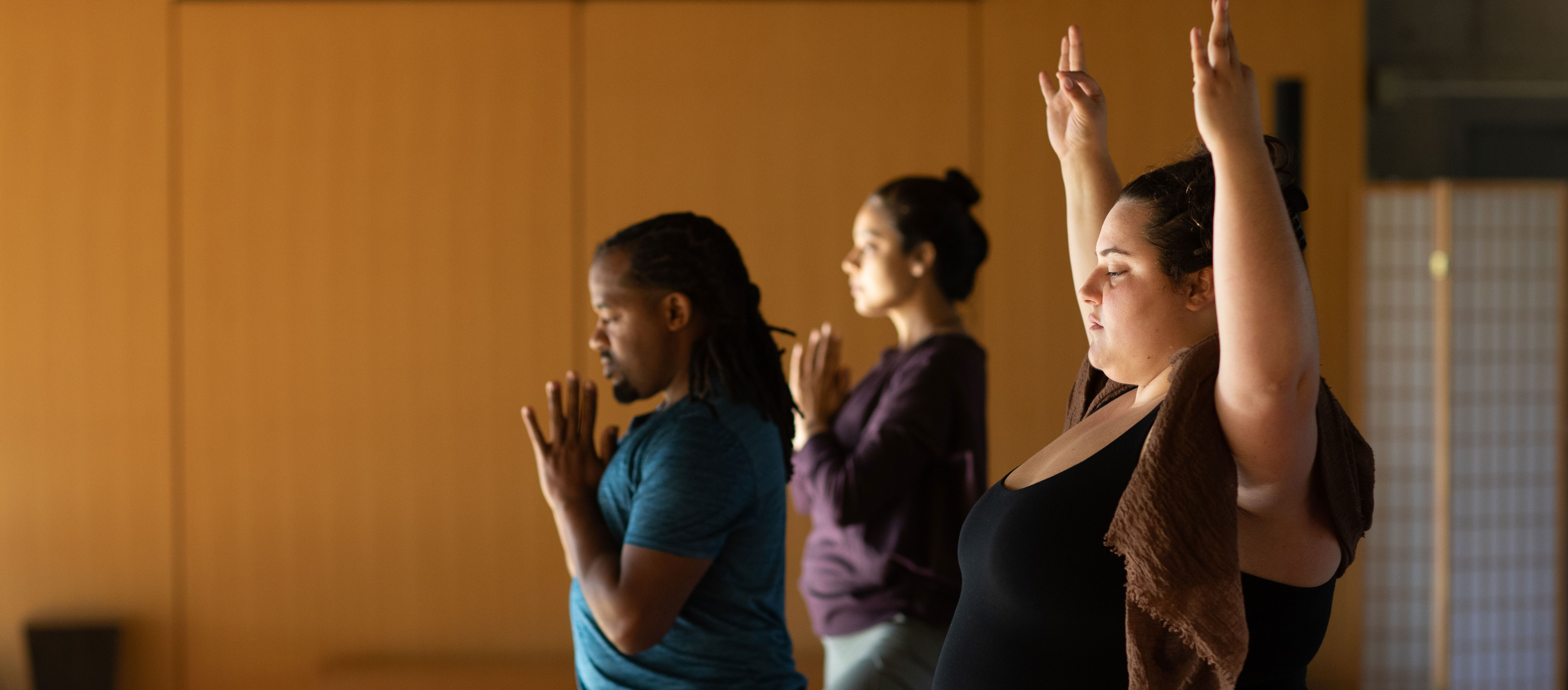 three yoga students with eyes closed