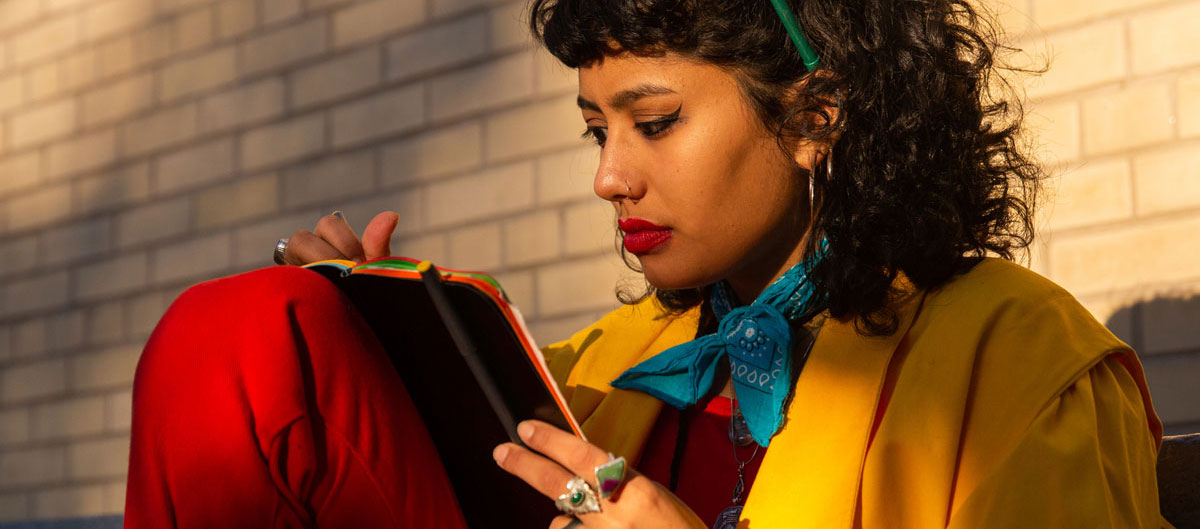 woman writing in journal outside