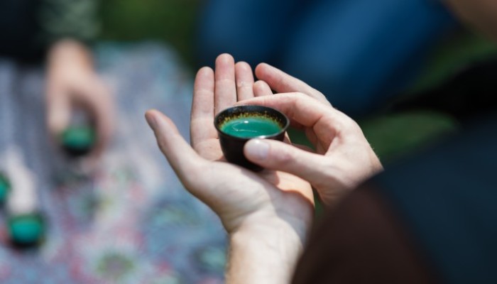 Person holding small cup of tea.